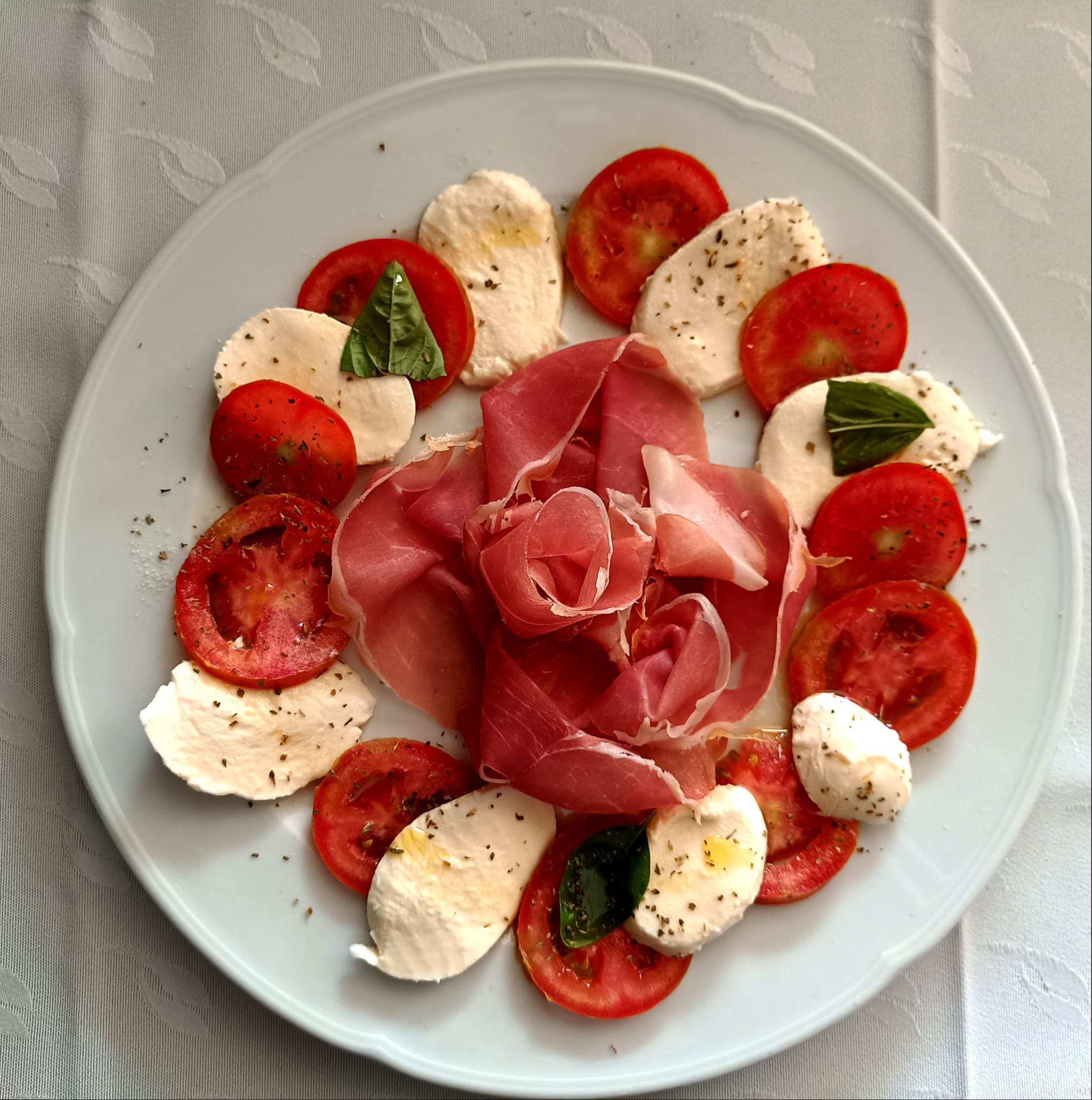Caprese di pomodoro e mozzarella con rosa di prosciutto crudo