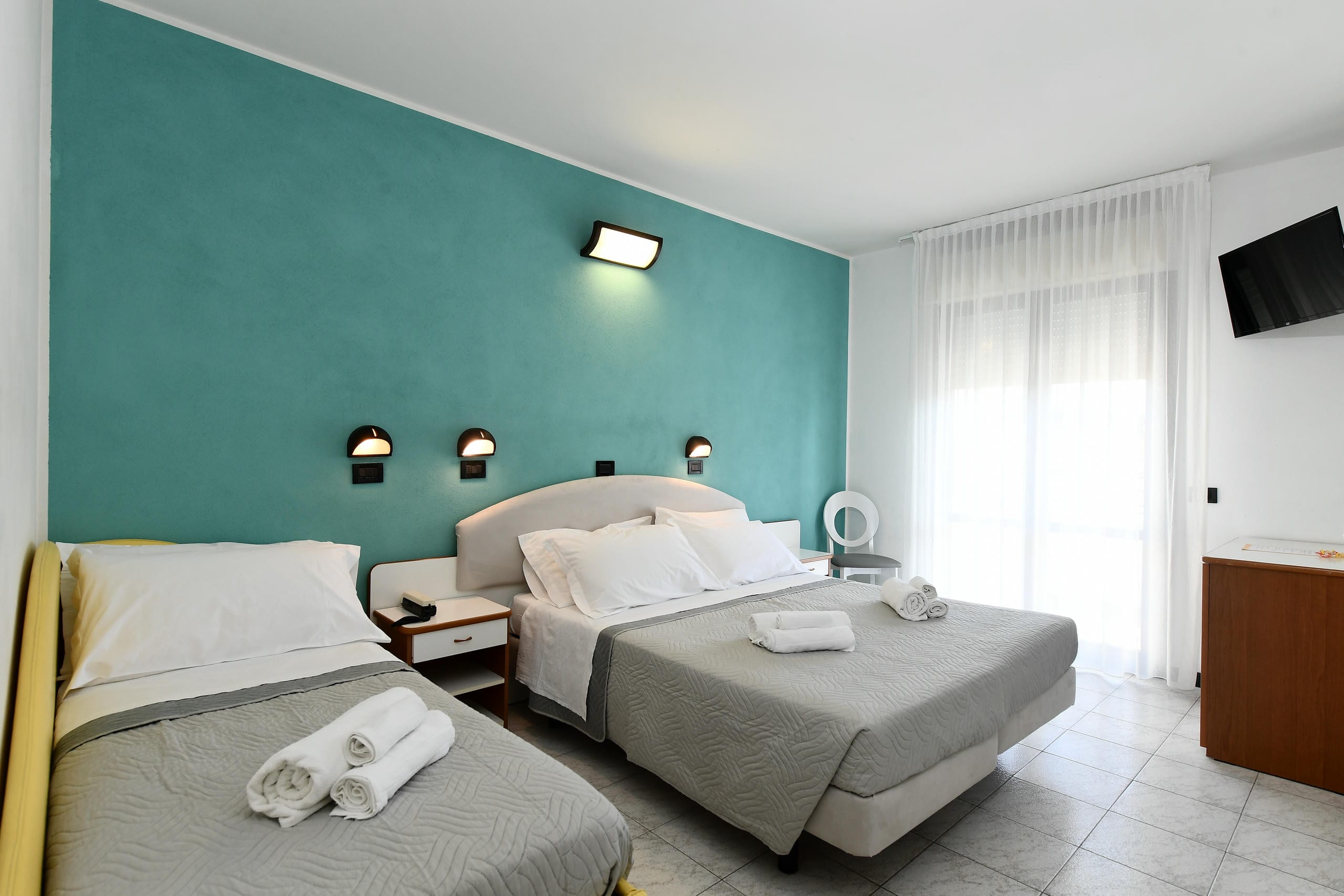 Camera Comfort, letto matrimoniale e singolo con parete verde acqua