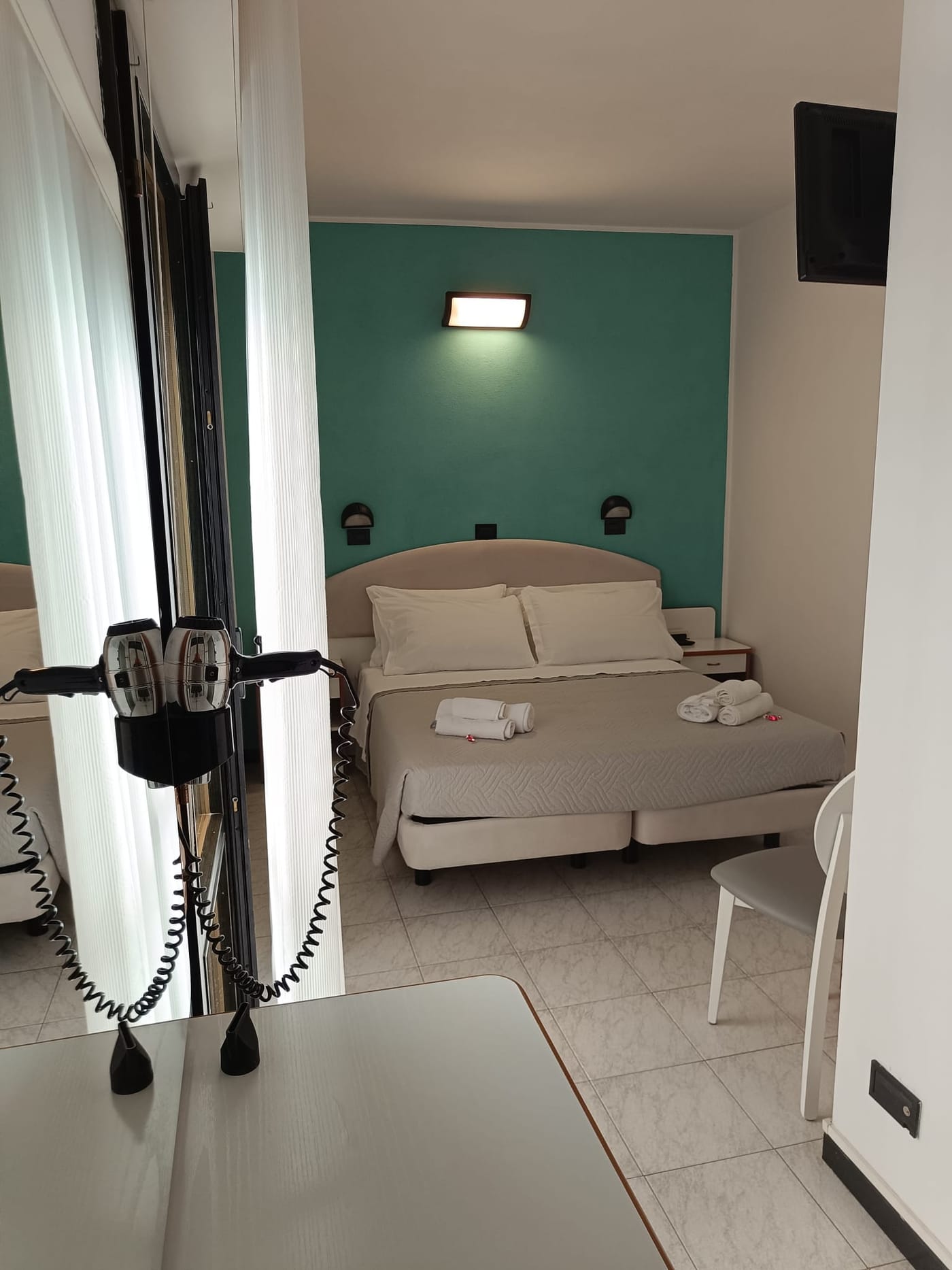 Camera Economy con parete verde acqua e letto matrimoniale