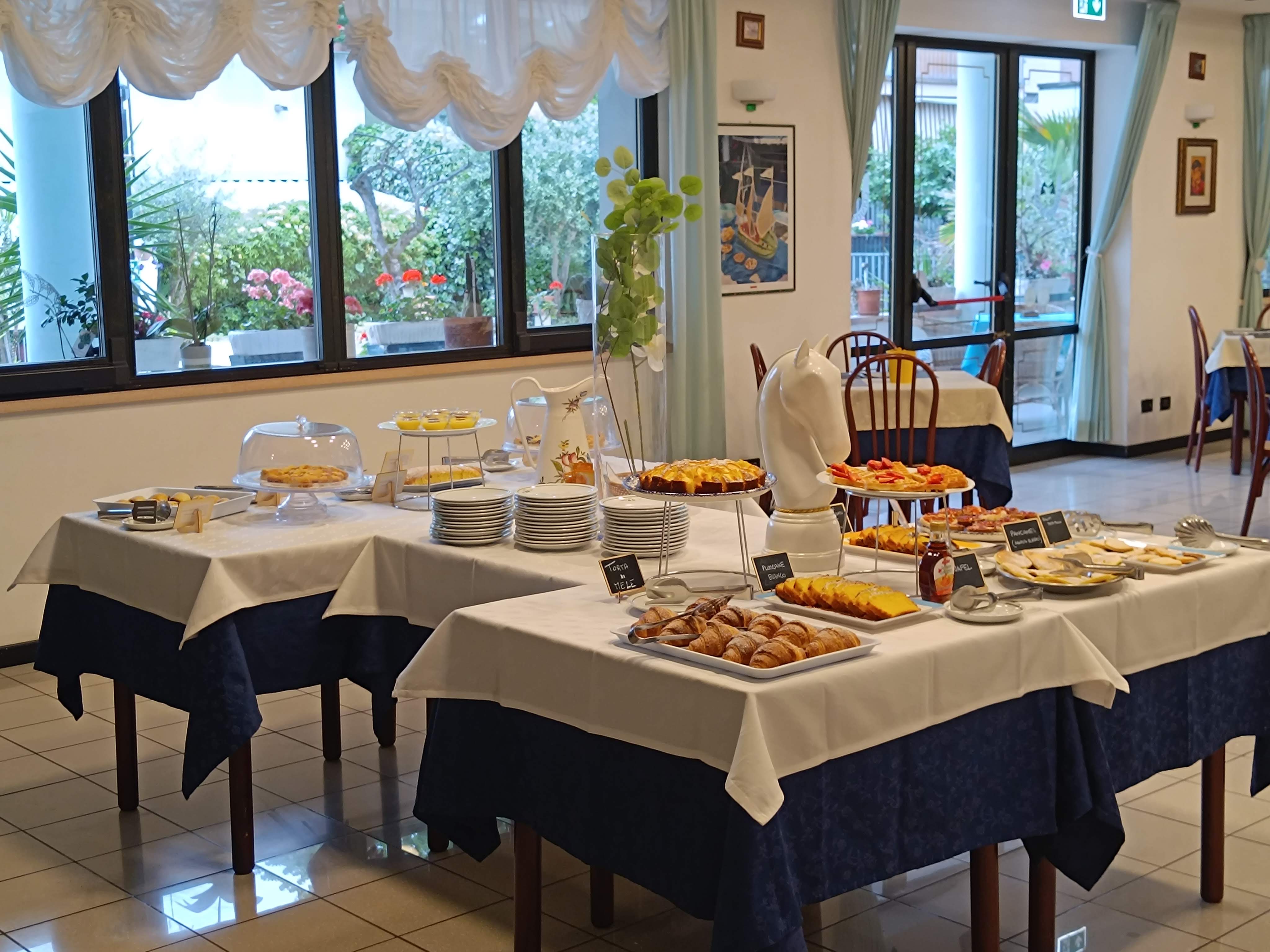 Buffet della colazione nella sala principale con torte e proposte salate