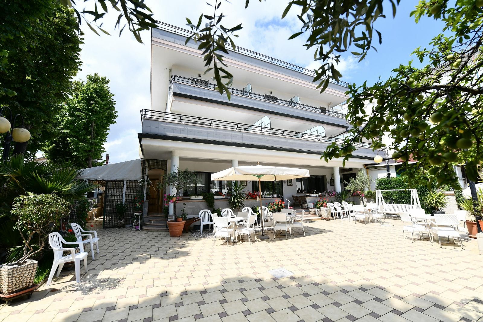Esterno dell'Hotel Criniera d'Oro con giardino e tavoli all'aperto